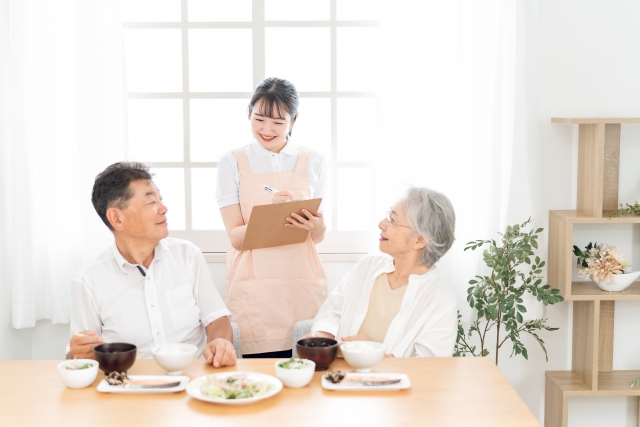 高齢者の食事をチェックする女性（栄養士）
