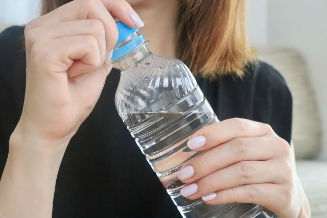 ペットボトルを持つ女性