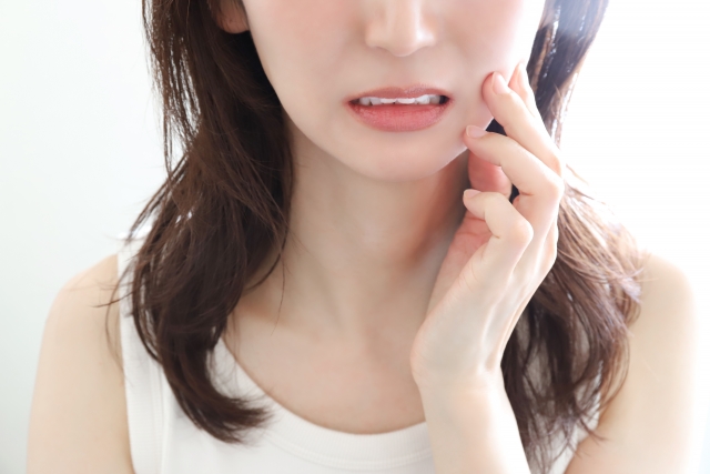 歯の痛みを感じる女性